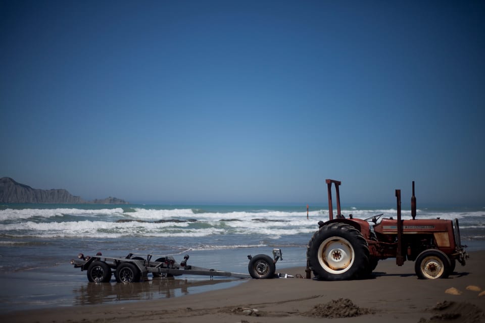 A tractor and trailer parked on Waimarama Beach, New Zealand - photo, copyright, leonie wise