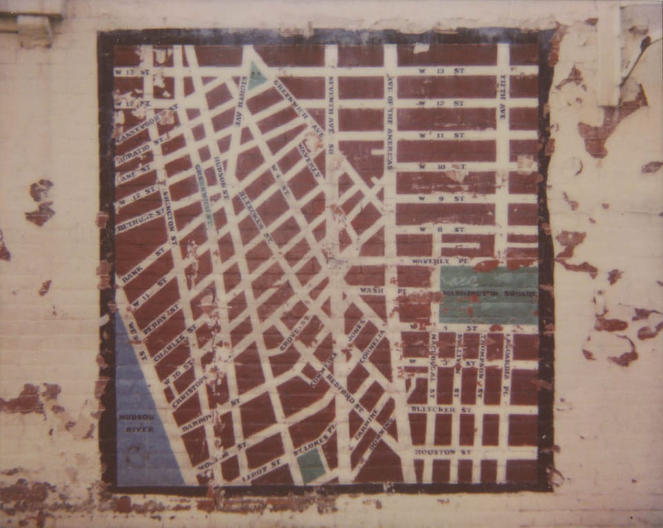 photograph, made with a polaroid spectra, of street art on a wall in the west village of new york city. the mural is on a cre